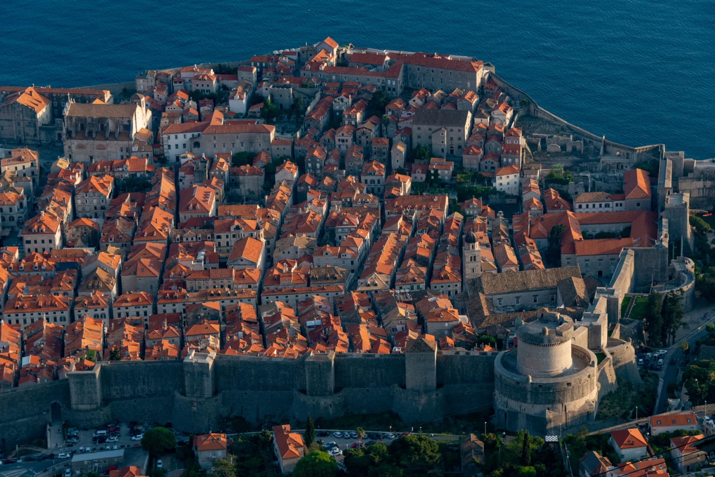 Dubrovnik Old Town rooftops enclosed by stone city walls beside the sea