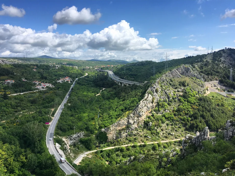 Winding roads through green and rocky hills viewed from Klis Fortress